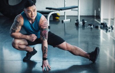 Best Tank Tops for Men Muscular Asian Man with Tattoos Working Out In a Gym