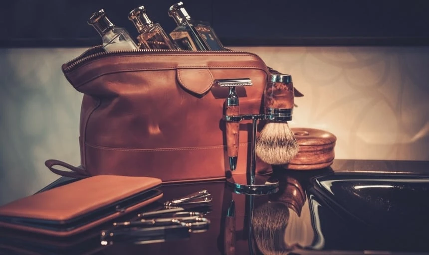 Men's accessories and wash bag with shaving kit on luxury interior