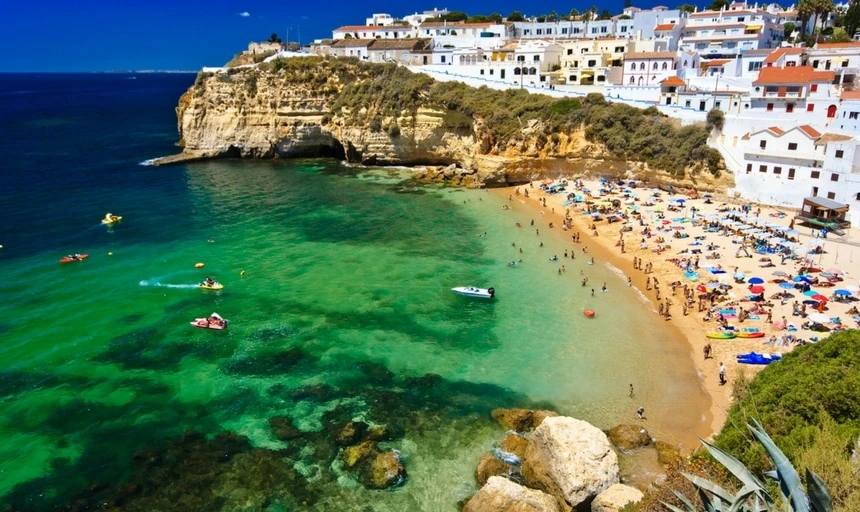 Algarve rock - coast in Portugal during day - boats and people on beach