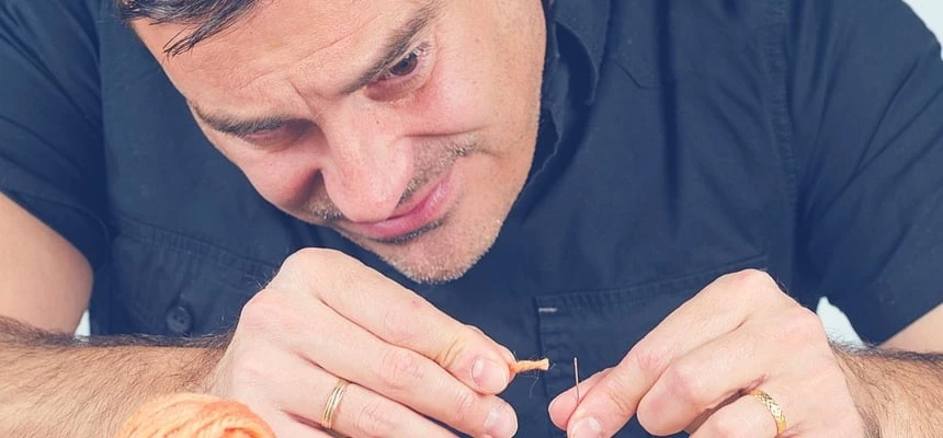 Man trying to sew and struggling Man trying to sew and struggling
