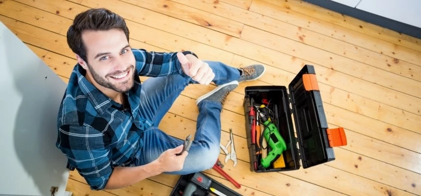 Man happy to be repairing kitchen sink Man happy to be repairing kitchen sink