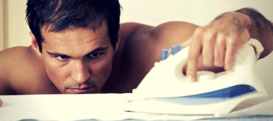 Man concentrating on ironing without a shirt on Man concentrating on ironing without a shirt on