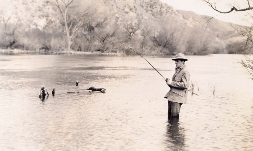 Man fishing quietly and patiently in river black and white