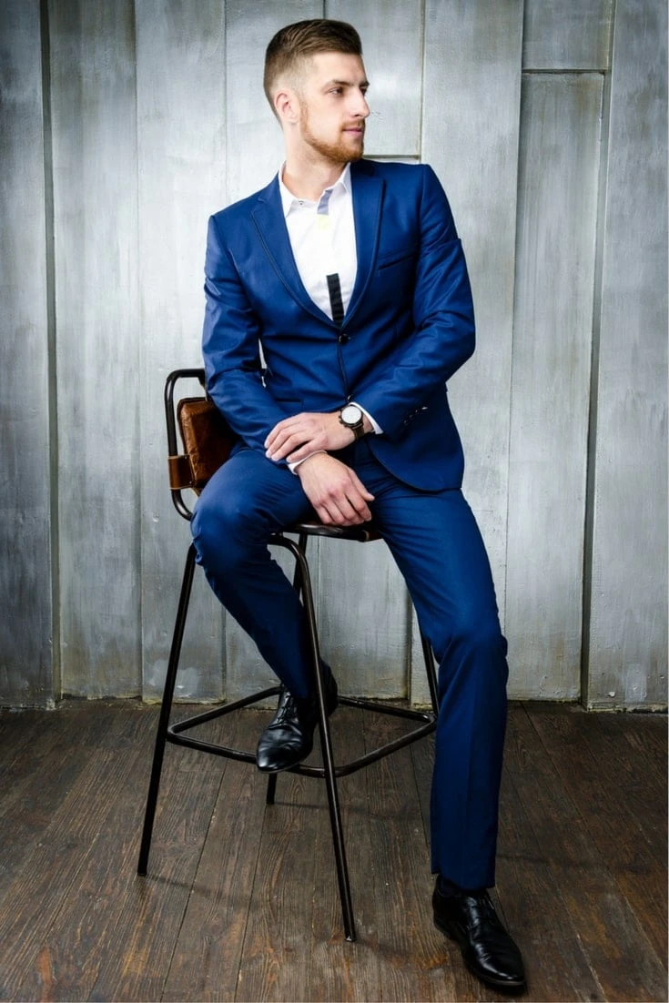 How to Match a Blue Suit with Brown Shoes in Style 61 Man in blue suit with black shoes sitting on a stool
