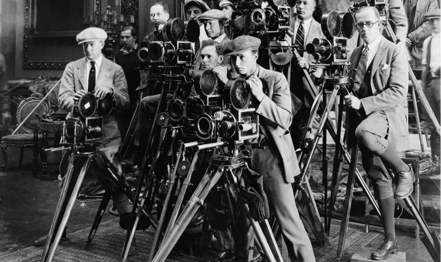 A bunch of photographers in business suits setup behind their cameras - black and white vintage