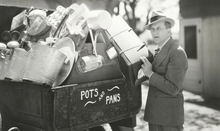 Man collecting pots and pans in a trailer - black and white