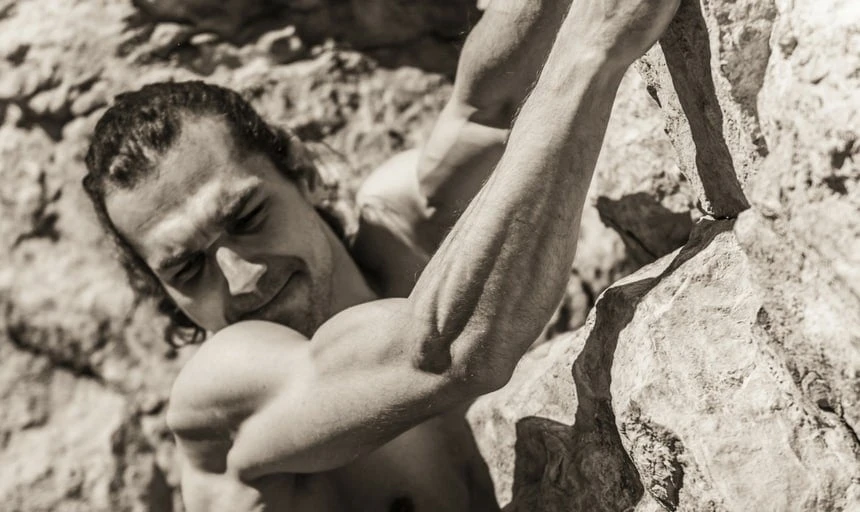 Muscular man rock climbing - vintage style