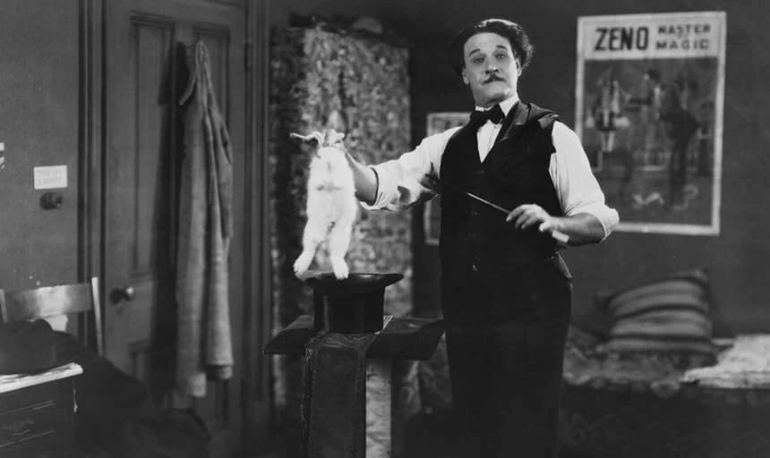 Old school magician pulling a rabbit out of a hat - black and white, vintage