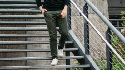 2020/02/Best-Chinos-for-Men_-Model-Wearing-Olive-Asket-Chinos-Walking-Down-Stairs-in-White-Sneakers.jpgw3.webp