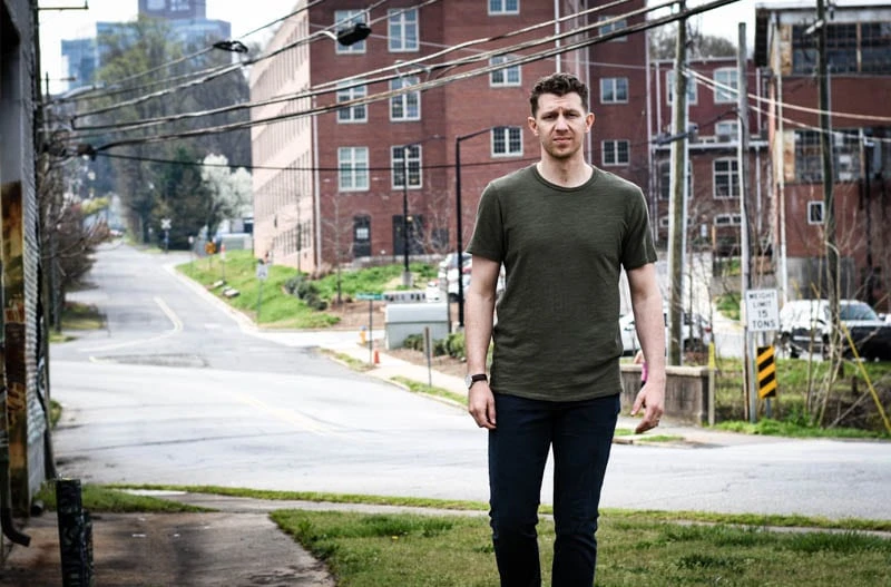 model in front of power cables wearing jeans and t shirt