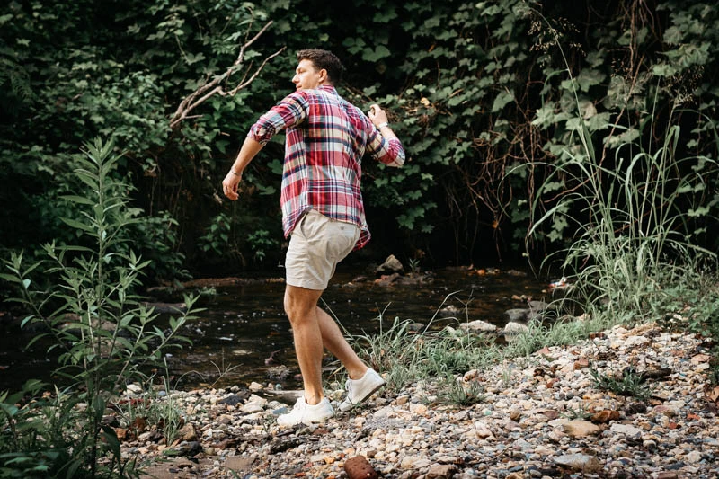 J.Crew Review for Men: Does the Legend Still Have It? 46 model wearing j crew button shirt and dock shorts skipping rocks by rier