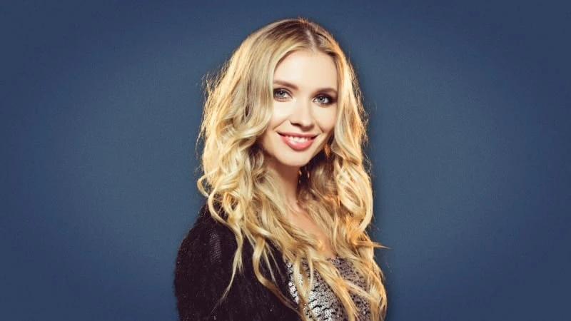 Attractive blonde woman smiling at camera on blue background 1