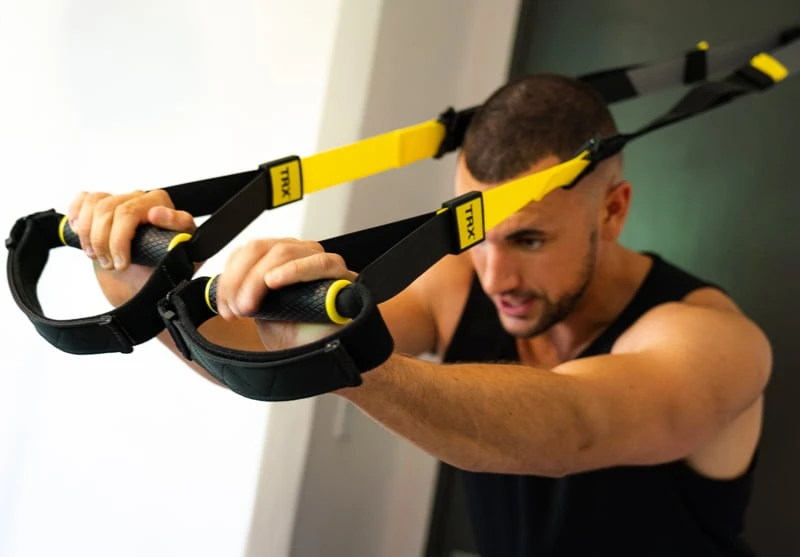 How to Build Muscle at Home: Bulk up With Minimal Gear in Your Living Room 38 Man doing triceps TRX 1