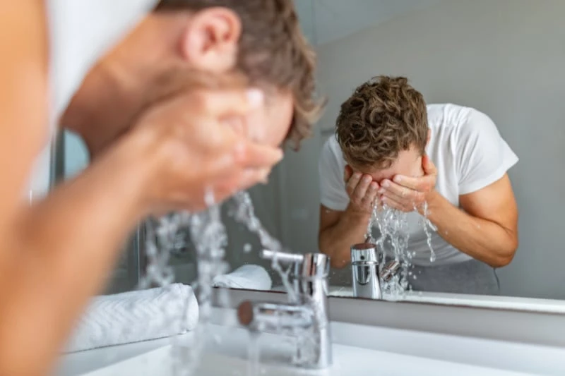 How to Care for Oily Skin: A Man’s Guide for 2024 49 man washing face with warm water