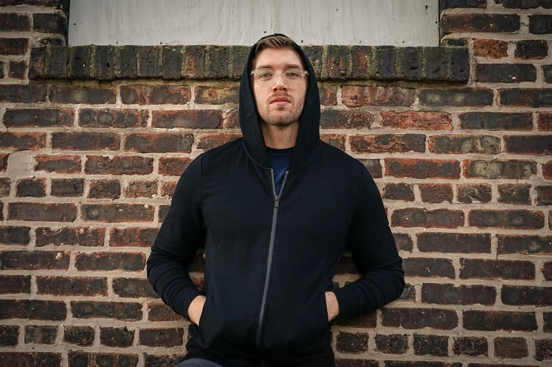 Unbound Merino Turns Luxe Wool into Utilitarian Might 55 man wearing black Unbound Merino hoodie and pants