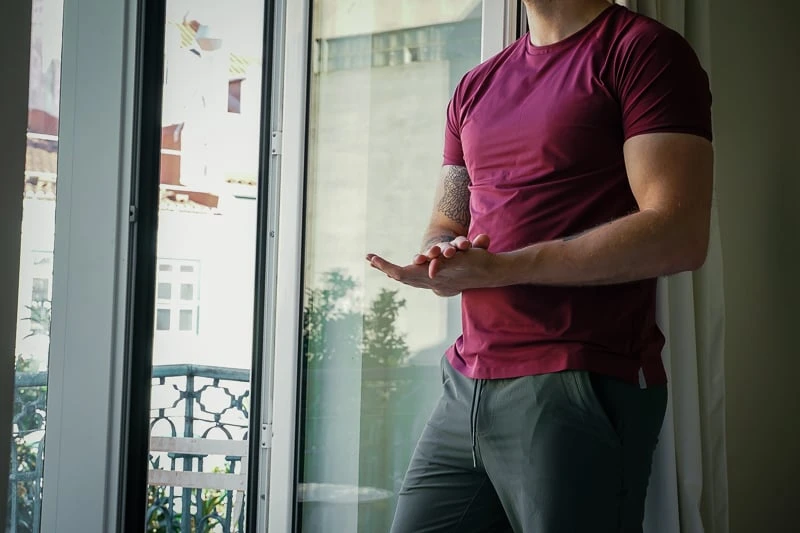 Alo Yoga Review: How Does This Activewear Brand Stand Out from the Rest? 42 Man by window wearing Alo Yoga Outfit