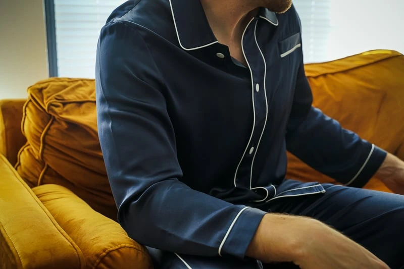 Man wearing Lilysilk pajamas on couch