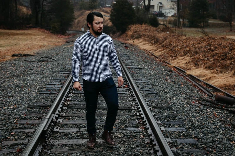 model walking on train tracks wearing under 510 gingham dress shirt