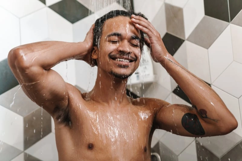 Black man in shower smiling
