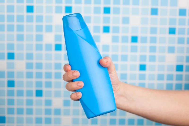 Man holding shampoo bottle
