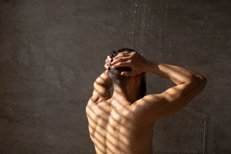 Man in shower with back turned
