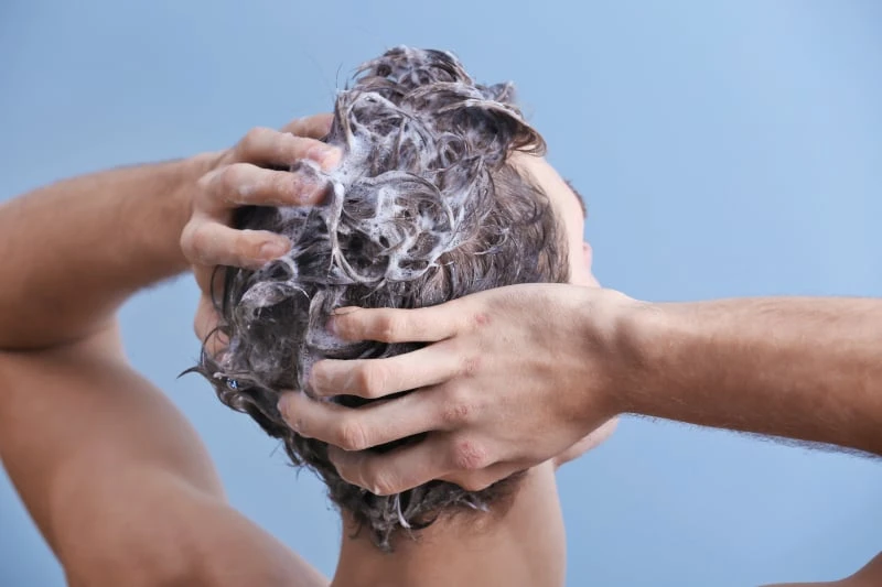Man shampooing hair reverse shot