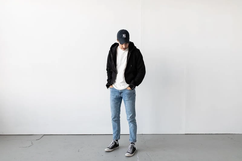 model with black zip hoodie and grey pants