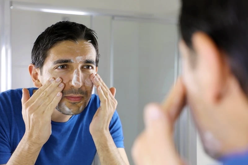 Man washing face with facial cleanser