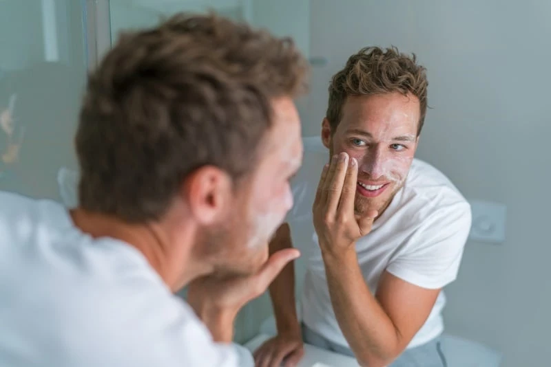Man washing face with soap scrubbing