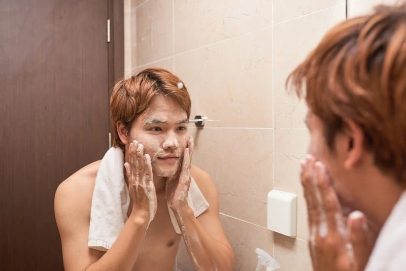 Portrait of asian man washing in bathroom