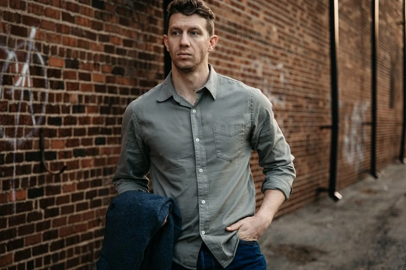 model wearing Buck Mason twill shirt in sage