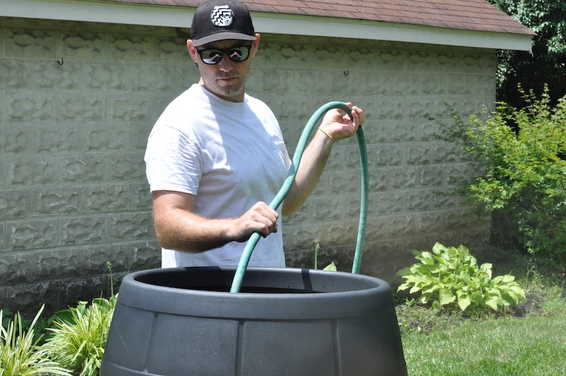 Male model filling black Ice Barrel with hose