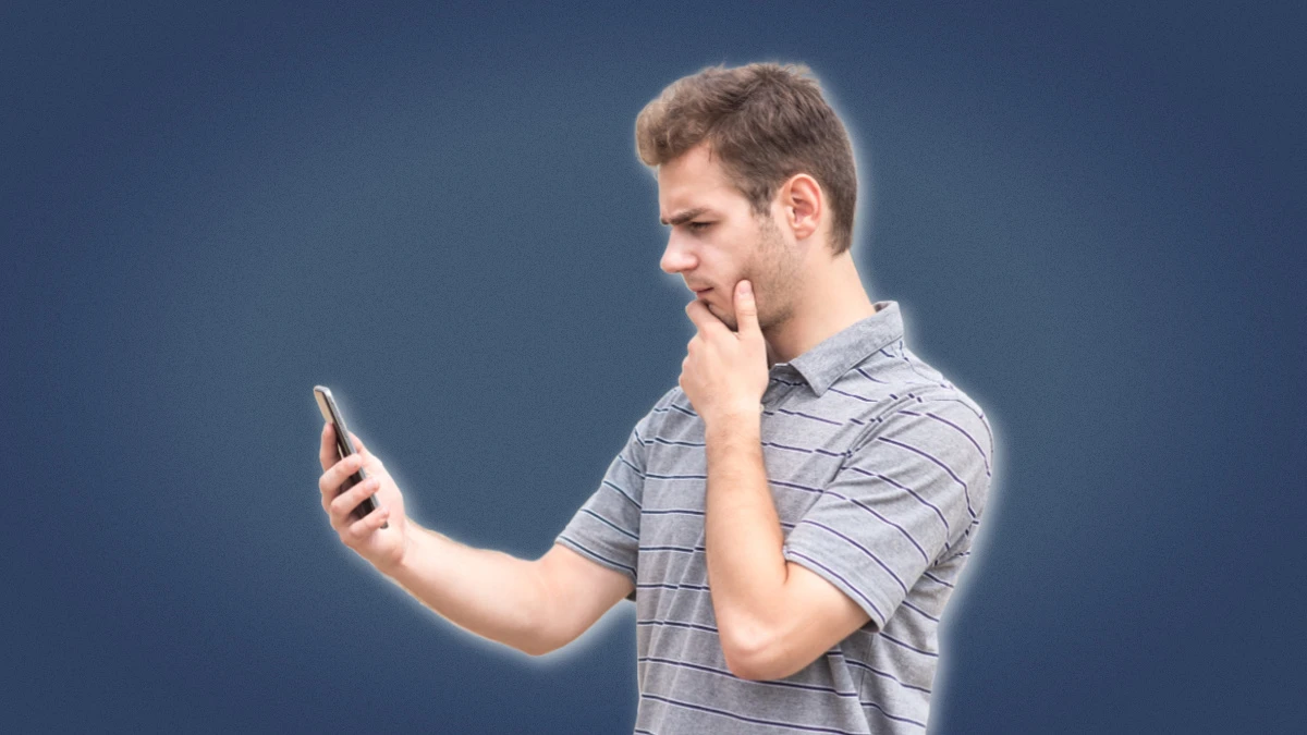 How often should you text a girl man puzzled while holding phone his hand and