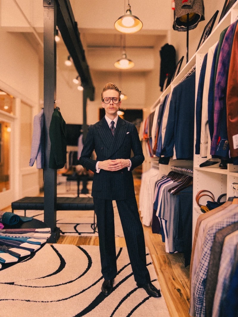 Model Standing while Wearing Black Striped Suit
