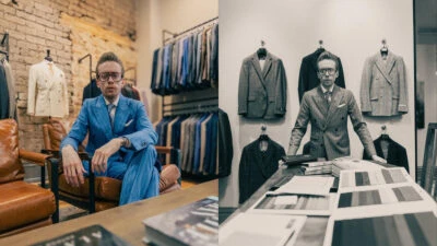 The-Adult-Man-Menswear-Consultant-Sitting-On-Chair-and-Leaning Over-Table-In-Front-Of-Suits