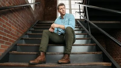 2024/07/The-Adult-Man-How-a-Man-Should-Dress-Casually-as-an-Adult-Model-Wearing-Boots-Chinos-and-Chambray-Shirt-in-Staircase.jpg.jpgw3.webp