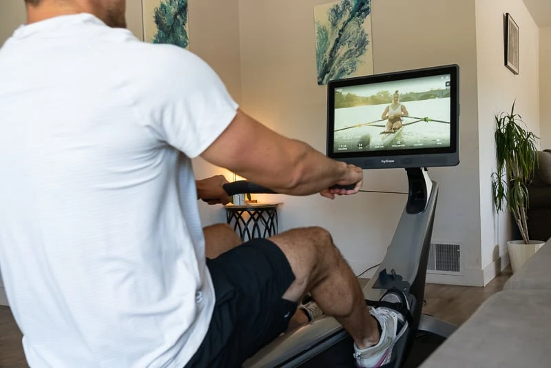 Model in living room on Hydrow Pro Rower